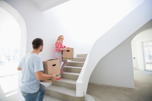Professional movers carrying furniture through a narrow stairway