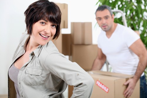 Same-day removals crew moving furniture through a narrow stairwell