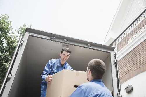 Local movers carrying items through a narrow stairwell in Bethnal Green apartment building
